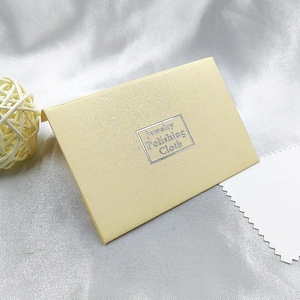 Detail view of pale yellow jewelry polishing cloth kit on elegant silk background