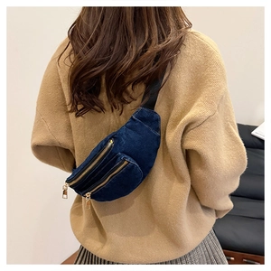 Close-up of durable dark blue denim chest bag featuring dual golden zippers and adjustable strap