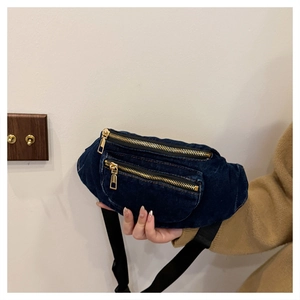 Detail of dark blue denim waist bag with double golden zippers and adjustable strap