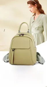 Detail view of water-resistant green leather backpack with soft litchi grain texture