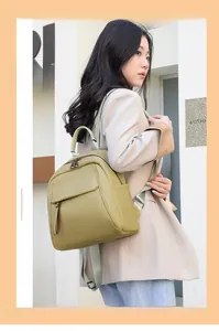 Outdoor shot of an olive green pebbled leather backpack worn by a model in nature