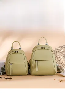 Detail view of olive green pebbled leather backpacks in two sizes with front flap pockets