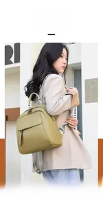 Side view of woman wearing a stylish light green leather backpack for outdoor travel