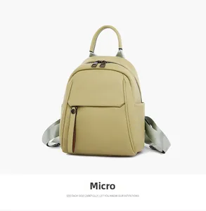 Slight side view of micro green leather backpack with soft litchi grain texture