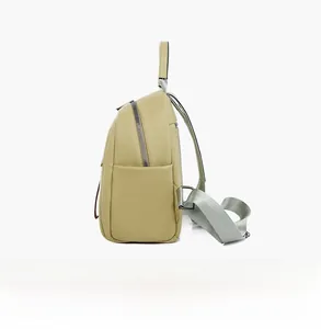 Side view of a soft pale green leather backpack for women with side pocket and nylon strap