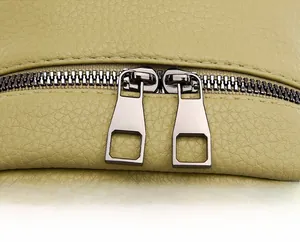 Detail of silver dual square zippers and litchi texture on green soft leather backpack