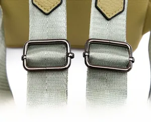 Macro shot of adjustable shoulder strap with silver metallic buckle and leather texture