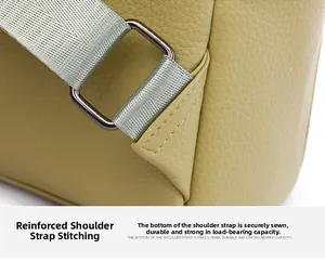 Close-up of reinforced shoulder strap stitching and metal buckle on soft green leather bag