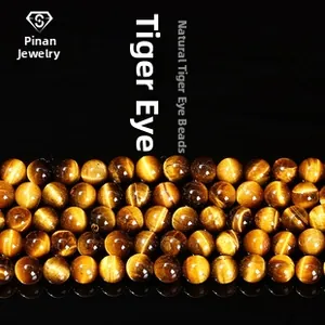 Macro shot of natural tiger eye loose beads with golden silk luster and brown stripes