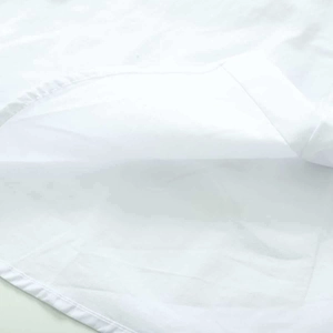 Gros plan sur le tissu du chemisier d'été blanc, texture coton-lin et coutures soignées