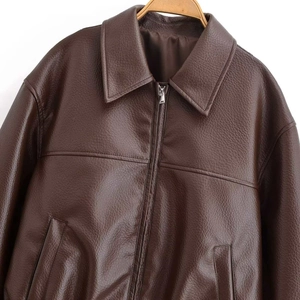 Vue détaillée de la texture du cuir marron foncé et du zip de cette veste vintage large