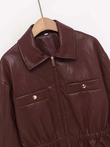 Makroaufnahme der dunkelroten Kunstlederjacke mit goldenen Knöpfen und Pattentaschen
