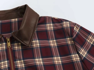 Primo piano della giacca a quadri rossa e blu con colletto in pelle marrone e zip metallica