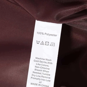 Detail view of burgundy polyester pilot jacket fabric with white washing care label