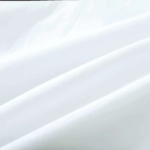 Gros plan détaillé montrant la texture tissée fine et les plis doux de la chemise blanche