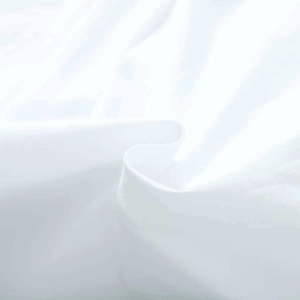 Gros plan du tissu blanc de la chemise à col claudine montrant une texture douce