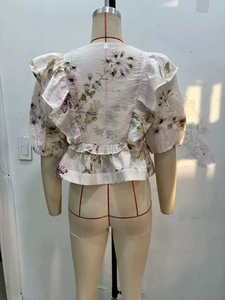 Détail de la blouse florale à manches bouffantes avec ourlet à volants et taille élastique