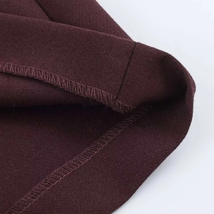 Dettaglio di pantaloncini bordeaux con tessuto strutturato e cuciture interne a sopraggitto