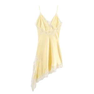 Détail d'une robe en satin jaune avec bordure en dentelle blanche et coupe asymétrique