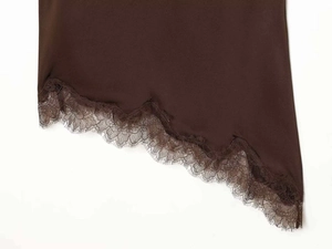 Detail of dark brown satin hem with delicate lace trim and asymmetric cut design