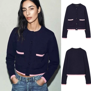 Close-up of navy knit cardigan featuring contrast pink ribbed trim and front patch pockets