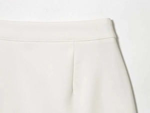 Detailed view of the waistline on white tailored skirt with elegant dart pleat details