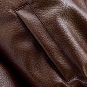 Détail macro de la texture de veste en similicuir marron et des coutures renforcées