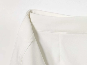 Close-up of white woven suit skirt showing detailed waist stitching and sewing craft