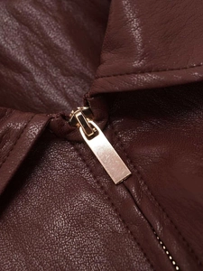 Detail einer burgunderroten Lederjacke mit hochwertigem goldenem Metallreißverschluss