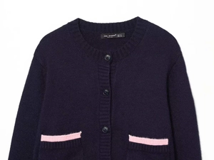 Detailed view of dark blue knit cardigan collar with pink contrast trim and buttons