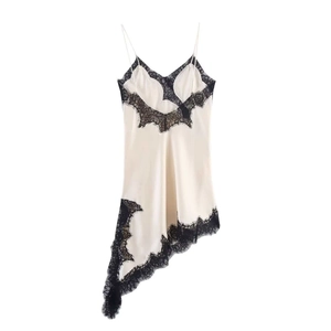 Détail de la robe nuisette en satin crème avec bordure en dentelle noire et ourlet asymétrique