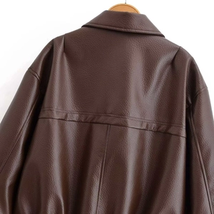 Détail du dos d'une veste en similicuir marron foncé avec texture grainée et couture