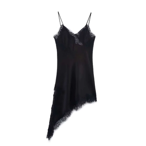 Détail d'une élégante robe nuisette en satin noir avec dentelle et ourlet asymétrique