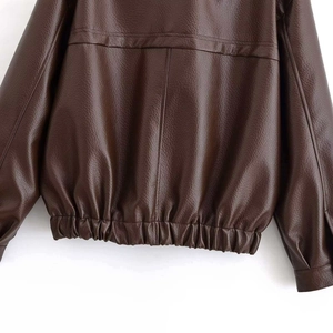 Détail de la veste en similicuir marron foncé avec ourlet élastique et texture grainée