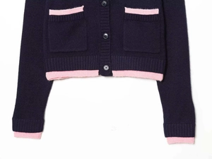 Detail view of navy knit cardigan with pink ribbed trim and front square pockets