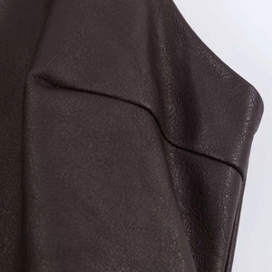 Gros plan sur la texture du cuir marron foncé grainé avec des surpiqûres industrielles
