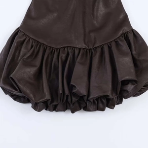 Gros plan détaillé d'une robe en similicuir marron foncé avec un ourlet bouffant plissé