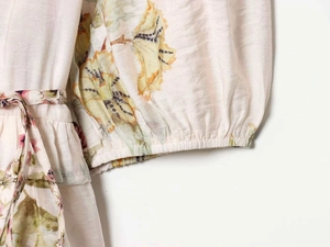 Détail de chemisier à fleurs avec manches bouffantes élastiques et ceinture à nouer