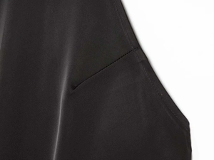 Close-up of black satin fabric showing fine stitching and smooth glossy texture detail