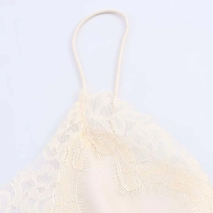 Détail du décolleté en dentelle délicate et fines bretelles sur une robe en soie