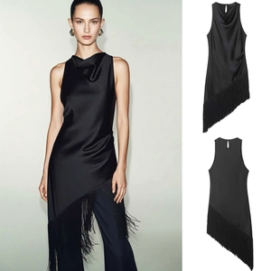 Detailed view of cowl neck and asymmetric fringe hem on this black satin sleeveless top