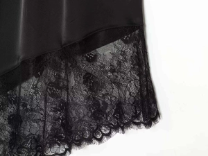Close-up of elegant black satin hem featuring intricate eyelash lace floral embroidery