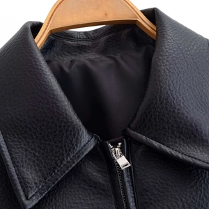 Détail de la veste en similicuir grainé avec col classique et fermeture éclair argentée