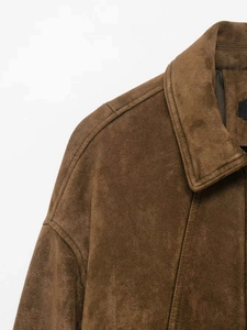 Dettaglio della texture in pelle scamosciata marrone scuro e cuciture di qualità sul colletto