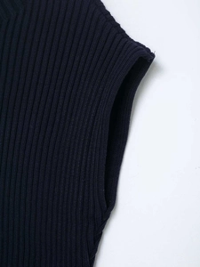 Gros plan sur la couture de l'emmanchure et la maille côtelée d'un débardeur bleu marine
