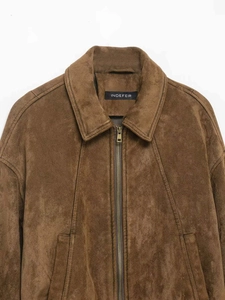 Dettaglio giacca vintage in pelle scamosciata marrone con zip e trama del collo