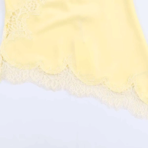 Detail shot of pale yellow summer top featuring delicate eyelash lace trim and embroidery