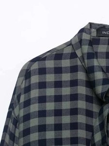 Detail of navy and green gingham shirt showing the collar, seam stitching and neck label