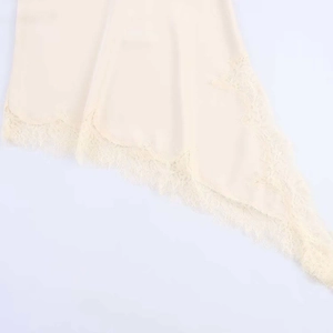Détails de l'ourlet en dentelle champagne avec bordure sur la robe asymétrique