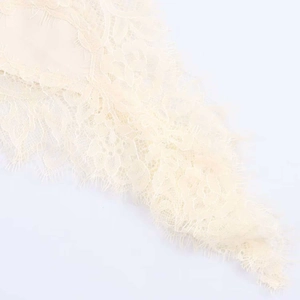 Détail de la dentelle de cils blanc cassé montrant des motifs floraux complexes
